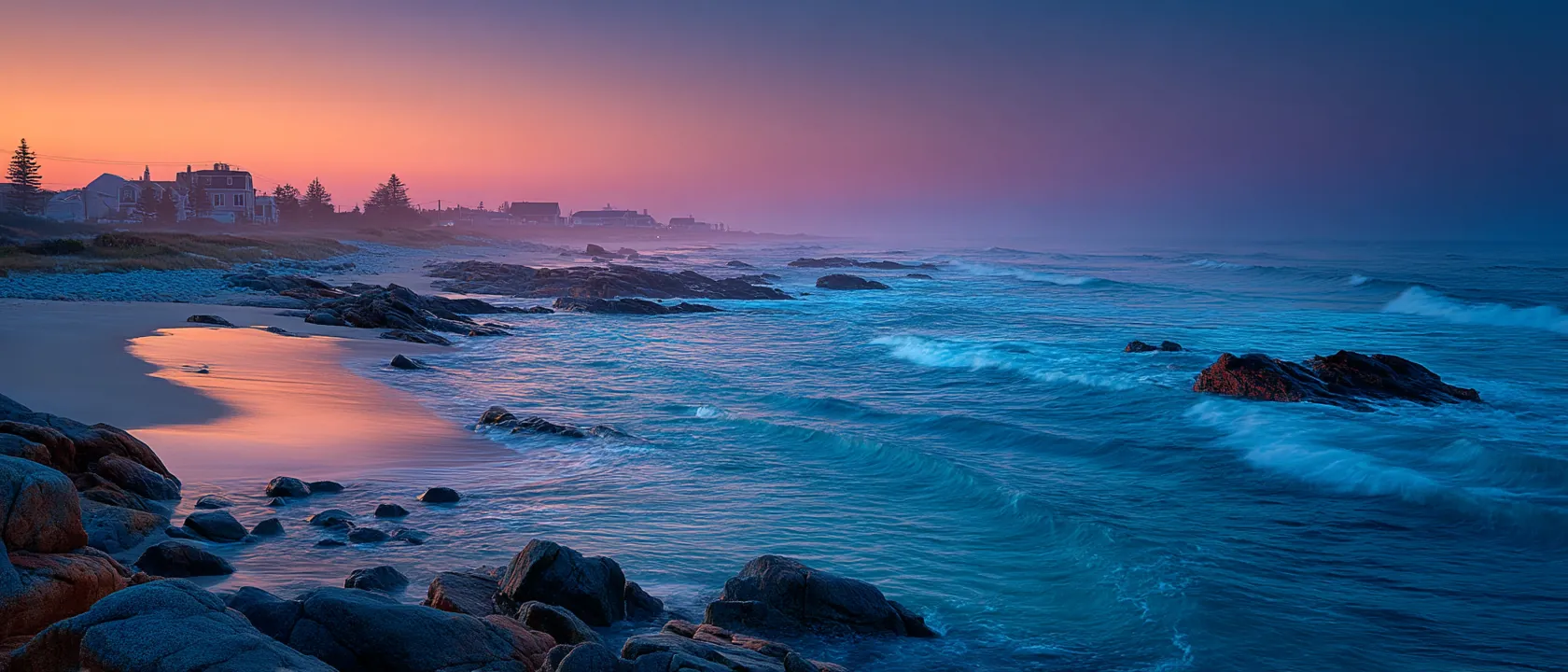 Blue hour coastal scene with cool blue light, deep saturated blue sky fading to warm orange at horizon, serene twilight atmosphere